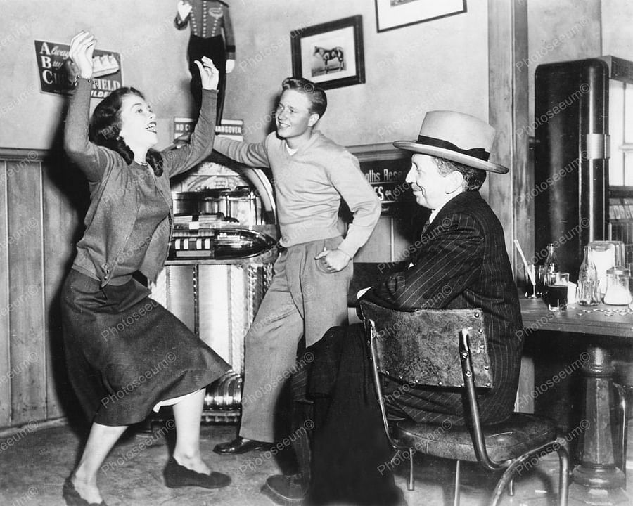 1950s teenagers gathered around a jukebox in a classic diner
